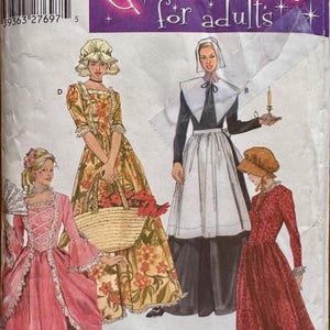 Puede incluir: Patrón de disfraz Simplicity para adultos. El paquete presenta ilustraciones de cuatro disfraces históricos diferentes: un vestido rosa, un vestido floral, un atuendo de peregrino y un vestido rojo. La palabra "Costumes" está en una fuente grande y decorativa.