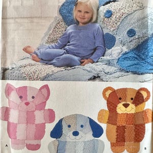 May include: Simplicity crafts pattern showing a child in blue pyjamas on a patchwork quilt. The pattern includes instructions for making stuffed animal toys: a pink bear, a blue dog, and a brown bear.