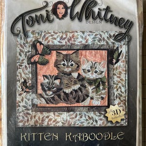 May include: A Kitten Kaboodle quilt kit by Toni Whitney Design. The kit features three adorable kittens surrounded by butterflies. The dimensions of the finished quilt are 16.75 x 19 inches.
