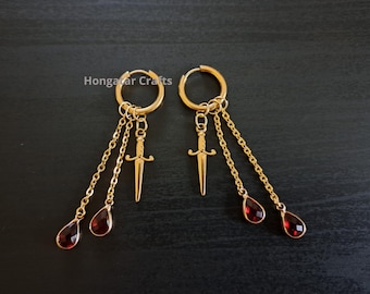 Pendientes de aro con forma de daga y gotas de sangre, tono dorado