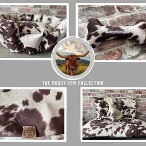 May include: A collection of dog beds and toys featuring a brown and white cow print pattern. The beds are made of soft, plush fabric and are available in a variety of sizes. The toys are made of durable, chew-resistant material and are perfect for dogs of all ages. The collection is called "The Moody Cow Collection" and is made by The Artisan Dog Co.