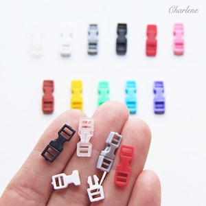 May include: A selection of small plastic buckles in a range of colours: black, white, grey, red, pink, yellow, green, blue, and purple. These buckles are suitable for crafts or sewing. The word "Charlene" is visible in the top right corner.