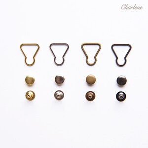 以下が含まれることがあります： 金属製のスライドバックルとそれに合うスナップボタンのセットが4つ。各セットには、金、銀、ブロンズのバックルとスナップボタンが含まれています。