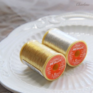 May include: Two spools of metallic thread, one gold and one silver, with labels that read "CHUIX METALLIC" and list the thread composition as 80% polyester and 20% paper. Each spool is 100 meters long.