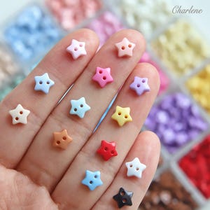 May include: A collection of small, star-shaped buttons in various colours including pink, blue, yellow, red, white, and black. Each button features two central holes for sewing. The word Charlene is printed in the upper right corner of the image.