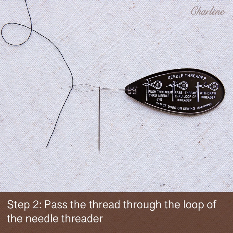 May include: A black needle threader with instructions on how to use it. The threader is on a white surface with a black thread and needle.