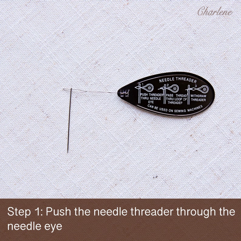 May include: A black plastic needle threader with instructions printed on it. The threader is threaded through the eye of a needle.