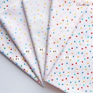 May include: Five fabric swatches with a white background and a scattered pattern of small hearts in various colours, including red, blue, yellow, pink, and green. The swatches are labelled #1 through #5.