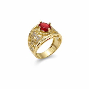 May include: A gold ring featuring a central oval-cut red gemstone held by four prongs. The band is wide with an intricate openwork geometric pattern and is accented with small, clear, sparkling stones embedded within the metal lattice structure.