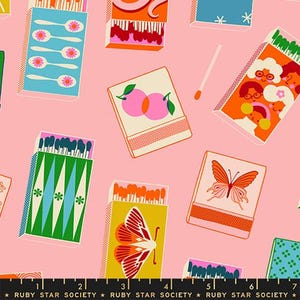 May include: Pink fabric with a repeating pattern of matchboxes. The matchboxes feature various designs, including spoons, butterflies, and illustrations of people. The fabric also includes the text "RUBY STAR SOCIETY" at the bottom.