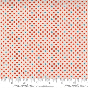 May include: Cream fabric featuring a repeating pattern of red polka dots and blue heart shapes. A ruler is along the bottom edge. The word "moda" is printed on the fabric.