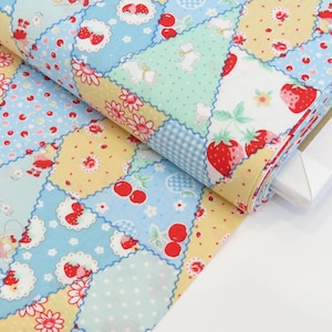 May include: Rolled fabric featuring a patchwork design with strawberries, cherries, and floral patterns in red, yellow, and blue. The fabric has a light blue gingham pattern and white accents. The fabric is rolled up and ready for use.