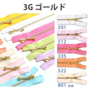 May include: A selection of zipper tapes in a range of colours, including red, yellow, pink, orange, green, blue, and white. Each zipper tape features a gold metal slider and pull tab. The zipper tapes are labelled with numbers, such as 501, 512, 335, 522, 801, 068, 506, 519, 544, and 874.