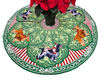 May include: A green Christmas tree skirt with a floral pattern and red and white striped border. The skirt features illustrations of birds and dogs. A poinsettia plant is in the center.
