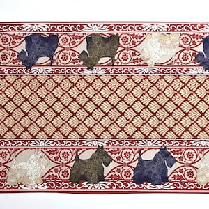 May include: A rectangular runner rug with a repeating pattern of dogs in various colors, including white, navy, and olive green. The rug has a red border with floral designs and a central diamond pattern.