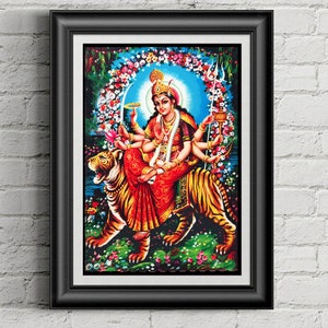 Puede incluir: Una pintura colorida de una diosa hindú montando un tigre. La diosa tiene múltiples brazos y está adornada con joyas. Está rodeada de flores y un halo azul. El tigre es marrón y negro con una raya blanca en la espalda.