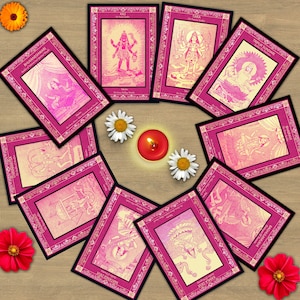 Peut inclure: Un ensemble de cartes à bordures roses et noires représentant des illustrations de divinités, disposées en cercle. Une bougie rouge allumée et plusieurs fleurs sont également présentes. Les cartes sont sur une surface en bois.