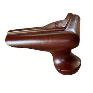 May include: A dark brown wooden furniture leg with a rounded ball foot and a silver metal trim. The leg is designed for a corner of a piece of furniture.
