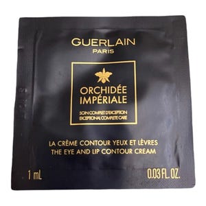 May include: A black packet of Guerlain Orchidée Impériale eye and lip contour cream. The packet has gold lettering and a gold orchid logo. The packet contains 1 mL or 0.03 fl. oz. of cream.