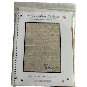 May include: A spiral-bound book titled "Janet's Ruler Quilt Design Book" in a clear plastic bag. The cover features a beige quilt design with the text "Sew Steady" and "60 x 40". The book is designed and quilted by Janet Collins.