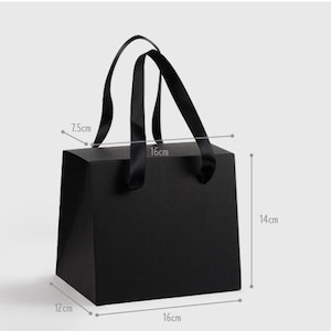 Op de afbeelding: Zwarte cadeauzak met zwarte lintjes. De tas is 16 cm breed, 14 cm hoog en 12 cm diep.