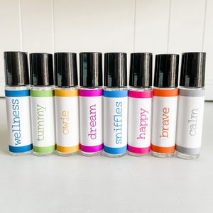 May include: Ten small glass roller bottles with black caps and colorful labels. The labels have the following words: wellness, tummy, owie, dream, sniffles, happy, brave, calm.
