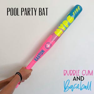 May include: A bright pink and blue baseball bat featuring the text HYPE FIRE in yellow, the word EASTON in blue, and a small circular logo. The bat is labeled POOL PARTY BAT, BUBBLE GUM AND BASEBALL, and has a textured grip area near the handle.
