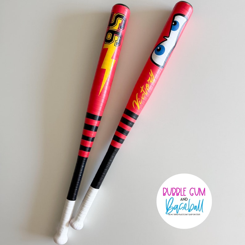 May include: Two red baseball bats with black and white grips. One bat features a yellow lightning bolt and the number "56". The other bat has cartoon eyes and the word "Victory" in yellow. The bats are from Bubble Gum and Baseball.