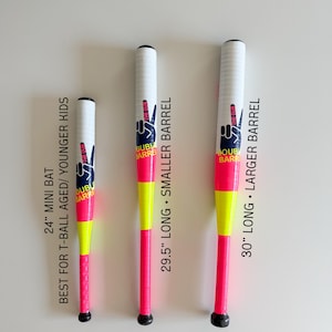 May include: Three baseball bats in white, neon pink, and yellow. Each bat features the text "THE DUB DOUBLE BARREL" and a peace sign graphic. The bats are 61 cm, 75 cm, and 76 cm long, suitable for different age groups.