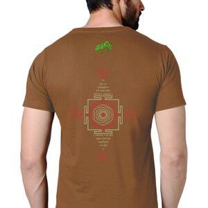 May include: Brown t-shirt with a green and white design on the back. The design includes a mandala, Sanskrit text, and the words "Om Gam Ganapataye Namaha".