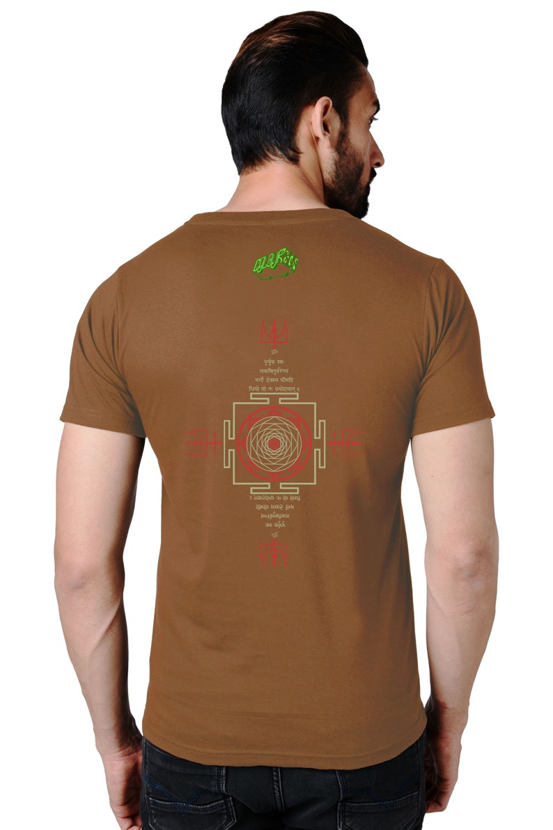 May include: Brown t-shirt with a green and white design on the back. The design includes a mandala, Sanskrit text, and the words "Om Gam Ganapataye Namaha".