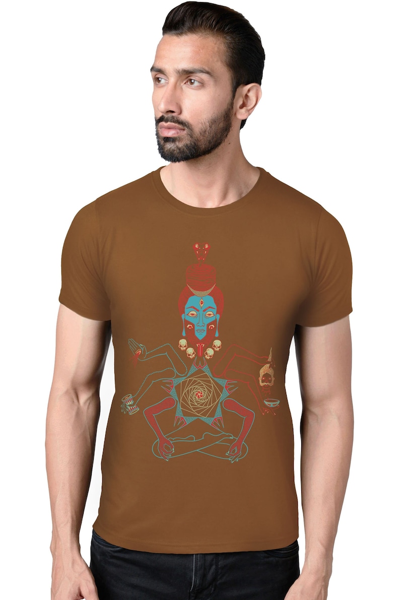 May include: A brown t-shirt with a graphic print of a multi-armed deity with a blue face and red and gold accents. The deity is sitting in a meditative pose with a skull and a bowl in each hand.