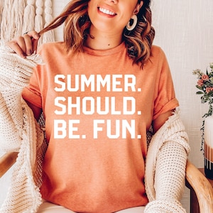 May include: A coral colored t-shirt with the text "SUMMER. SHOULD. BE. FUN." in white.