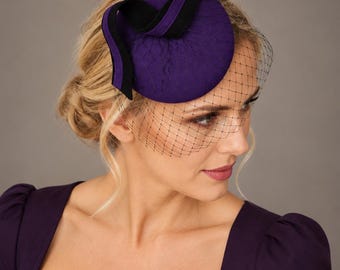 Lila filtfascinator med fågelburslöja, svart rosett, bröllops- och tävlingshatt