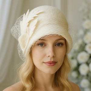 Elegancki, inspirowany stylem vintage kremowy filcowy kapelusz ślubny typu cloche z welonem