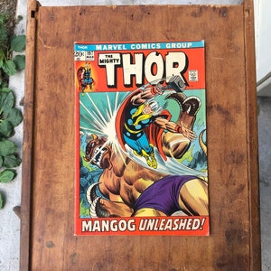 May include: A vintage Marvel Comics Thor comic book with the title "The Mighty Thor" and the tagline "Mangog Unleashed!" The cover features Thor in a battle with a large, monstrous creature.