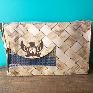 May include: A brown cardboard box with a woven pattern and a brown eagle logo. The box has a blue mesh window.