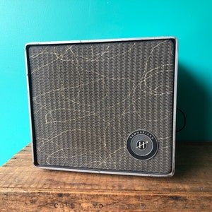 May include: A vintage gray speaker with a textured fabric grille and a black circular label with the text "Hammarlund" and a stylized "H" inside.