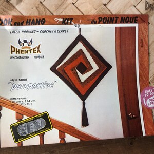 May include: A latch hook kit for a wall hanging called "perspective". The kit includes yarn, instructions, and a latch hook tool. The finished wall hanging is a square with a brown, orange, and white swirl design. The wall hanging is 30 inches by 45 inches.