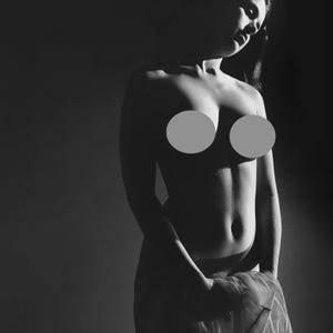 May include: A black and white photo of a person standing in a dark room, wearing a sheer fabric draped over their body.