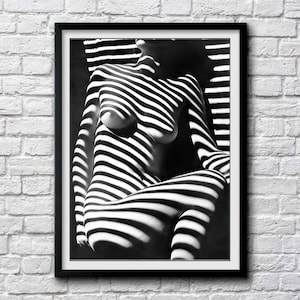 May include: Black and white photograph of a person's body with light and shadow creating a striped pattern.