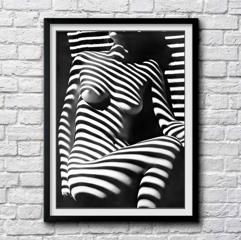 May include: Black and white photograph of a person's body with light and shadow creating a striped pattern.