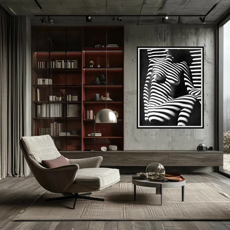 May include: A black and white photograph of a person's torso with stripes of light and shadow. The photo is framed and hanging on a wall in a modern living room.
