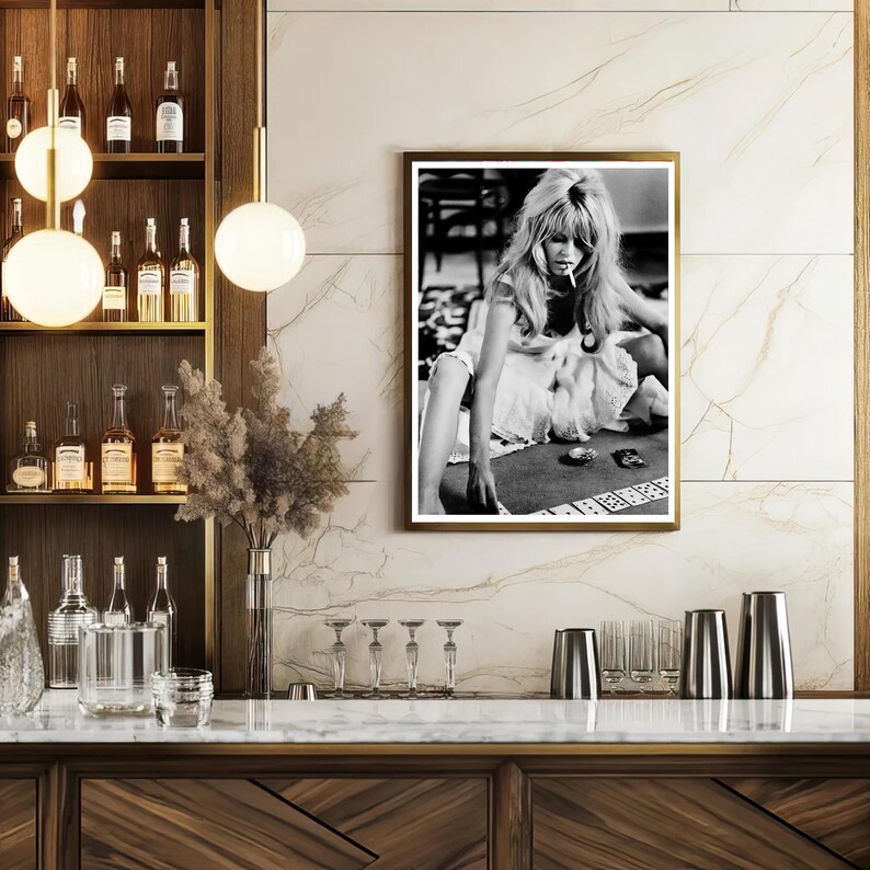 May include: A framed black and white photograph of a woman playing cards, mounted on a marble wall. The photograph is displayed above a wooden bar with bottles, glasses, and decorative lighting.