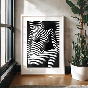 May include: Black and white photograph of a person's torso and legs, with light and shadow creating a striped pattern.