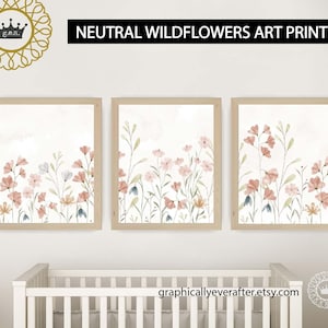 May include: Three framed watercolour prints of neutral wildflowers in shades of pink and green. The prints are hung on a white wall above a white cot.