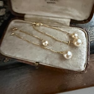 Elegantes perlas de agua dulce en dos colgantes de cadena chapados en oro, para pendientes perforados.