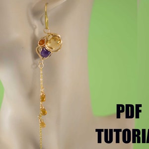 May include: Gold wire wrapped earrings with a cluster of yellow, orange, and purple gemstones. The earrings have a long, dangling chain with smaller yellow gemstones.