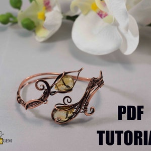 Könnte beinhalten: Ein mit Kupferdraht umwickeltes Armband mit zwei gelben Edelsteinen. Das Armband ist mit einem Blattmotiv gestaltet und enthält ein PDF-Tutorial.