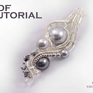 Könnte beinhalten: Ein handgefertigter Anhänger aus Silberdraht mit grauen Perlen und Kristallen. Der Anhänger hat ein einzigartiges, abstraktes Design mit dem Text "PDF TUTORIAL" oben links. Das Wire Up Gem-Logo befindet sich unten rechts.